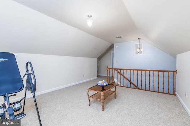 interior space featuring carpet floors, lofted ceiling, visible vents, an upstairs landing, and baseboards