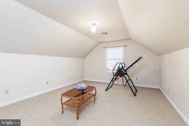 exercise area with visible vents, baseboards, vaulted ceiling, and carpet flooring