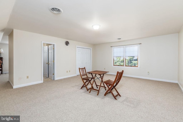 dining room featuring visible vents, light carpet, and baseboards