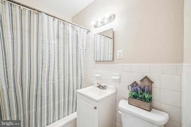 full bathroom with toilet, vanity, tile walls, and a shower with shower curtain