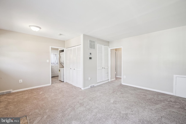 unfurnished bedroom featuring light carpet, visible vents, and baseboards