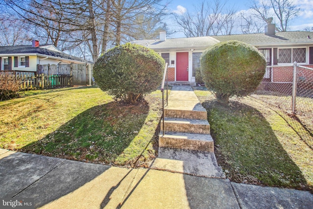 view of front of house featuring a front yard, brick siding, and fence