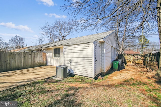 back of property with a fenced backyard and central air condition unit