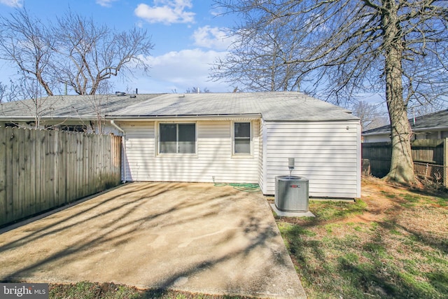 rear view of property with fence, a patio, and central AC unit