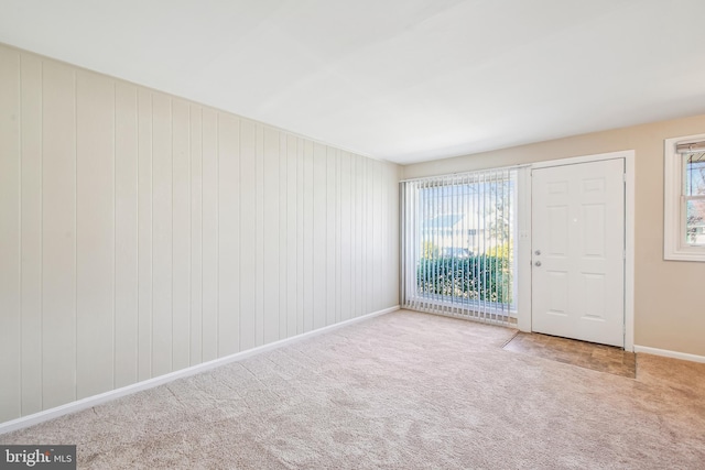 unfurnished room with light colored carpet and baseboards