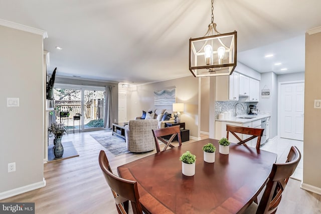 dining room with a chandelier, light hardwood / wood-style floors, and sink