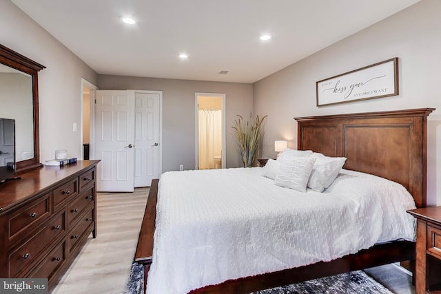 bedroom featuring ensuite bath and light wood-type flooring