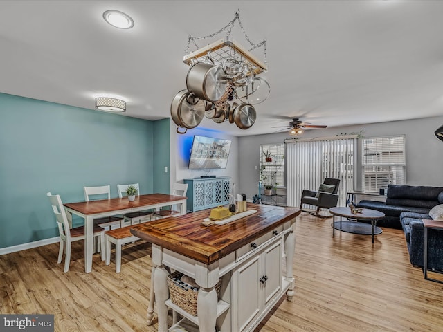 kitchen featuring butcher block counters, white cabinetry, open floor plan, and light wood-style flooring