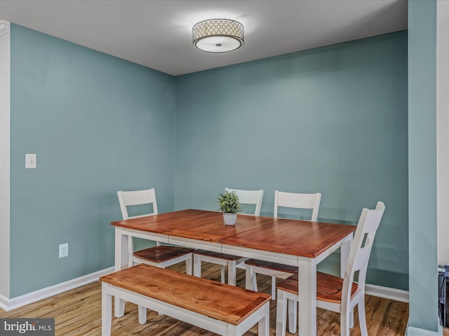 dining area with baseboards and wood finished floors