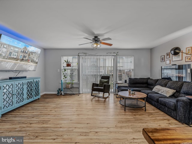 living area featuring light wood-type flooring, plenty of natural light, and a ceiling fan