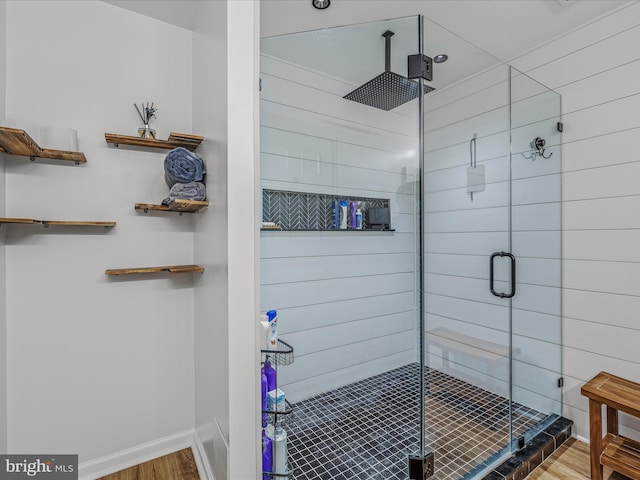 bathroom featuring a shower stall, baseboards, and wood finished floors