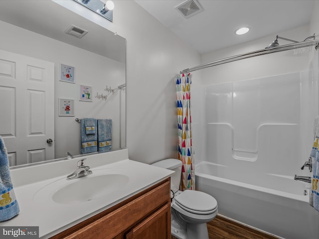 full bath featuring toilet, shower / tub combo, wood finished floors, vanity, and visible vents