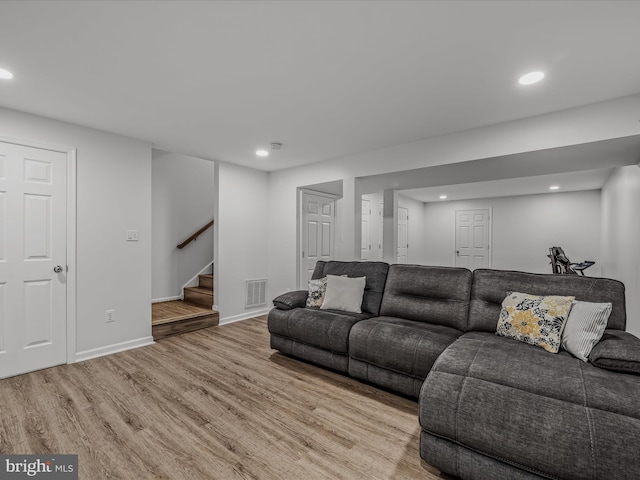 living room with recessed lighting, visible vents, baseboards, stairway, and light wood-type flooring