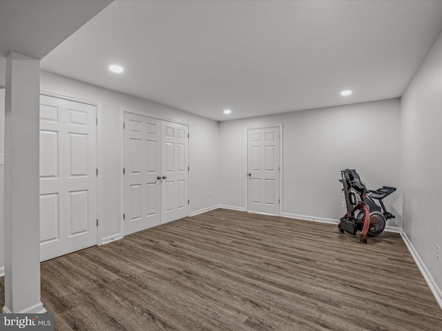 below grade area featuring baseboards, dark wood-type flooring, and recessed lighting