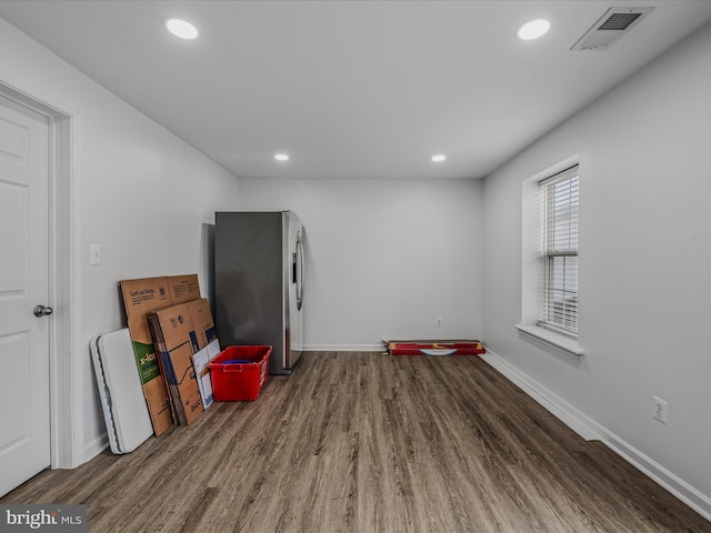 interior space with dark wood-style flooring, visible vents, and baseboards