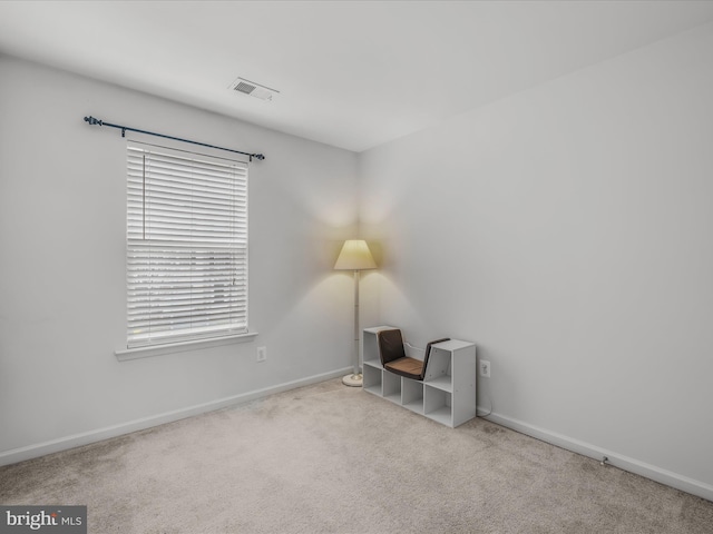 interior space with baseboards, visible vents, a wealth of natural light, and light colored carpet