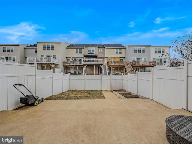 view of patio / terrace featuring a garden, a fenced backyard, and a residential view