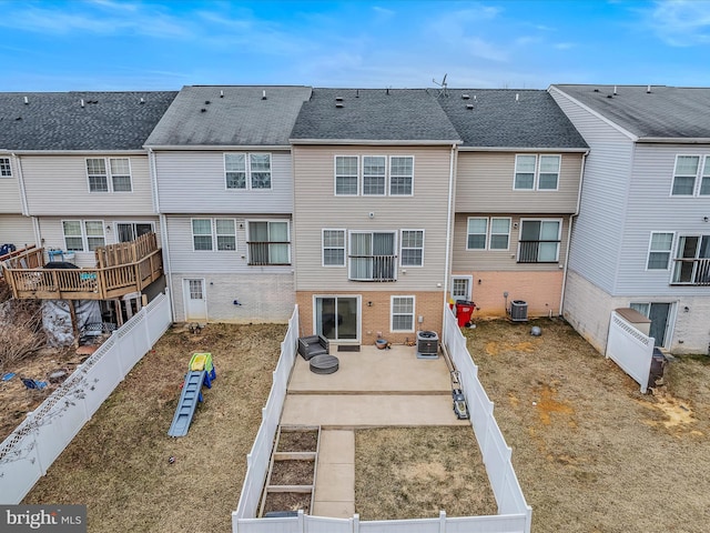 rear view of property with a patio area, a fenced backyard, and central AC