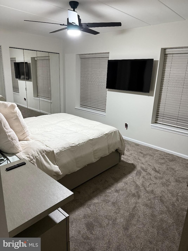 bedroom with ceiling fan, dark carpet, and a closet