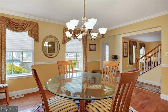 dining room with ornamental molding, a chandelier, and hardwood / wood-style floors