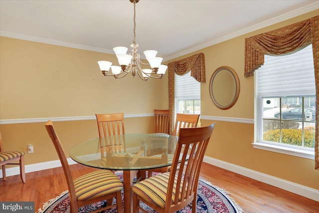 dining space featuring hardwood / wood-style flooring, crown molding, and a notable chandelier