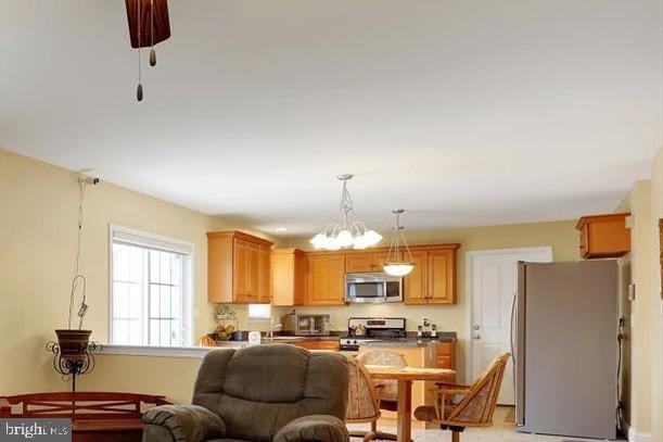 kitchen featuring stainless steel appliances, a chandelier, and decorative light fixtures