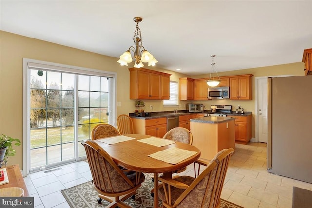 tiled dining area with sink and a chandelier