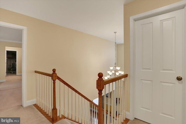 hallway featuring carpet and an inviting chandelier