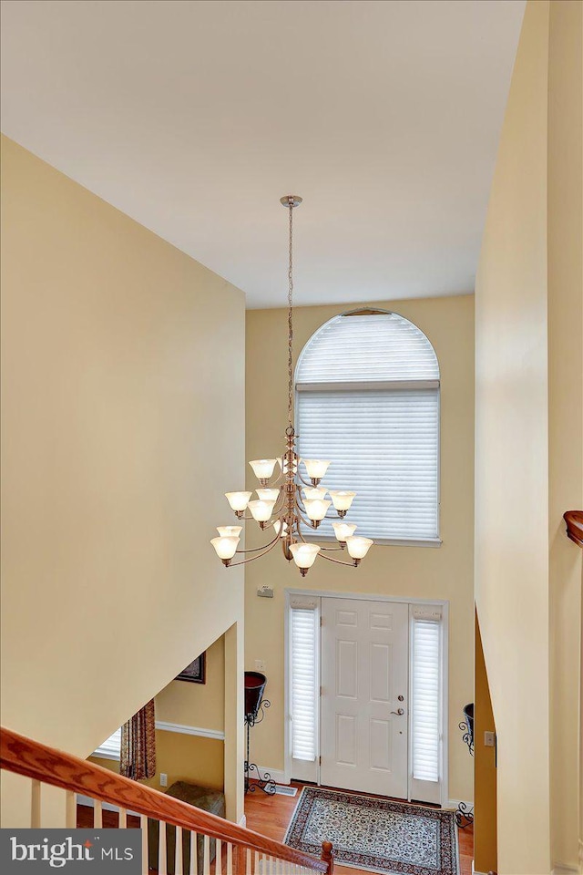 foyer entrance with a chandelier and a high ceiling