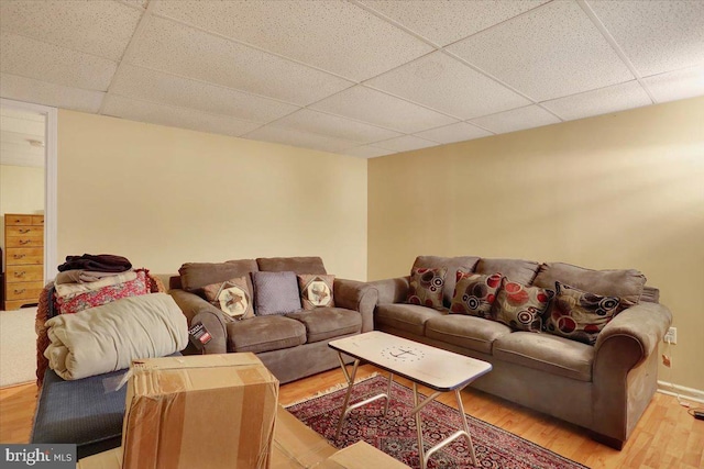 living room with a paneled ceiling and light hardwood / wood-style floors