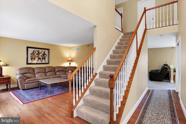 stairway featuring hardwood / wood-style floors and a high ceiling