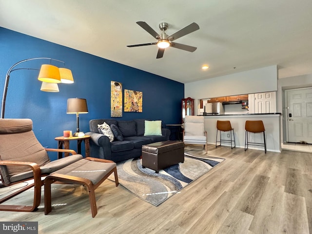 living room featuring light hardwood / wood-style flooring and ceiling fan