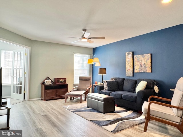 living room featuring ceiling fan and light hardwood / wood-style floors