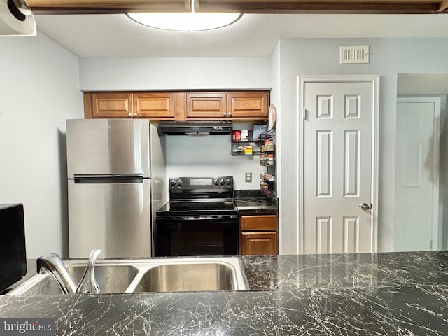 kitchen with sink, stainless steel fridge, black electric range, and dark stone countertops