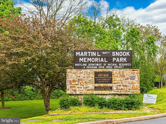 community / neighborhood sign featuring a lawn