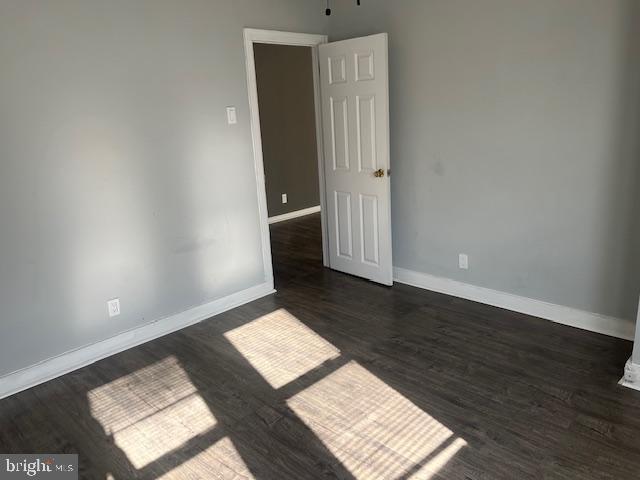 empty room featuring dark wood-type flooring