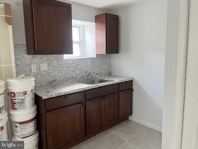 kitchen featuring tasteful backsplash, sink, and dark brown cabinetry