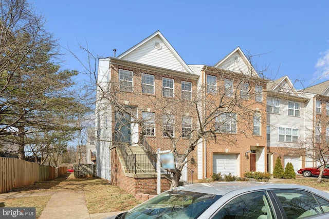 view of property featuring brick siding and fence