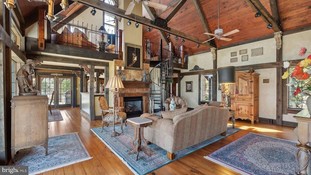 living area featuring high vaulted ceiling, beam ceiling, decorative columns, and wood finished floors