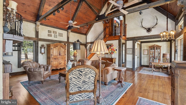 living area with high vaulted ceiling, wood ceiling, beam ceiling, and wood finished floors