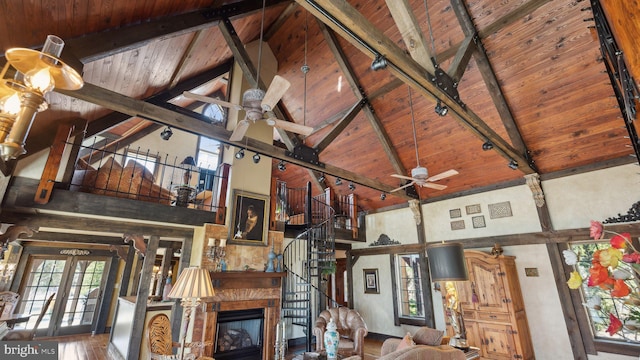unfurnished living room with ceiling fan, wood ceiling, stairway, beamed ceiling, and rail lighting