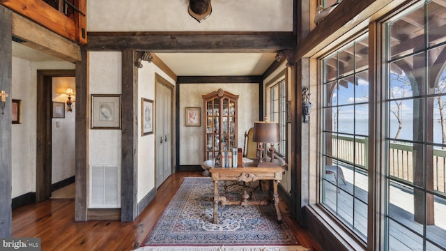 office with beam ceiling, visible vents, dark wood finished floors, and baseboards