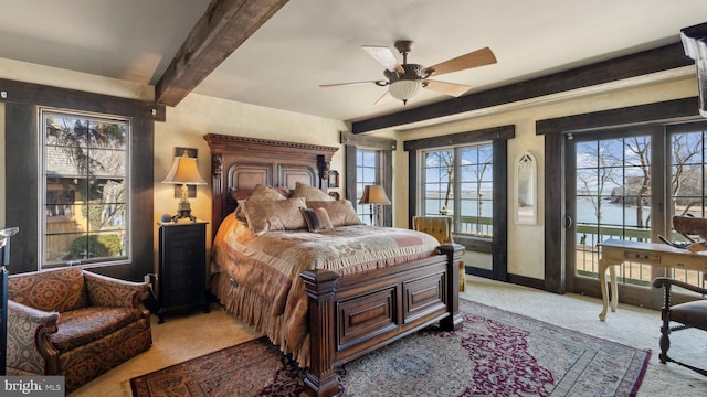 carpeted bedroom featuring access to outside, multiple windows, baseboards, and beam ceiling