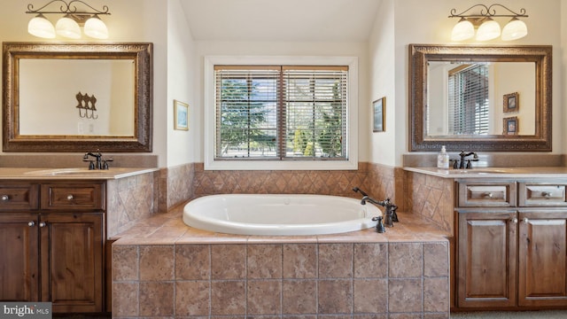bathroom with a garden tub, two vanities, and a sink