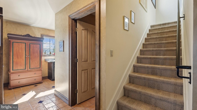 stairway with tile patterned flooring and baseboards