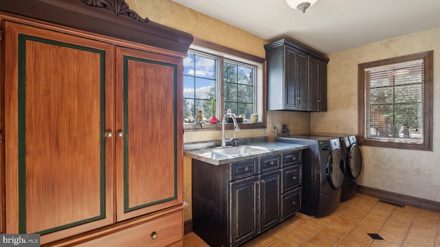 laundry room with a sink, visible vents, baseboards, washer and dryer, and cabinet space