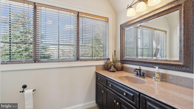 bathroom with lofted ceiling and vanity