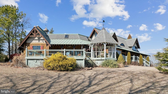 rear view of property with metal roof, a standing seam roof, and a gazebo