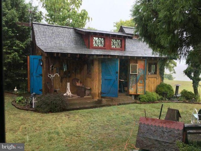 back of house with an outbuilding and a yard