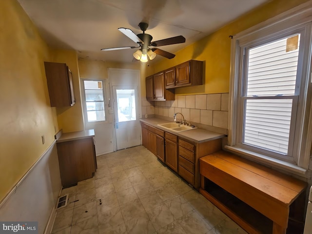 kitchen featuring sink, ceiling fan, and decorative backsplash